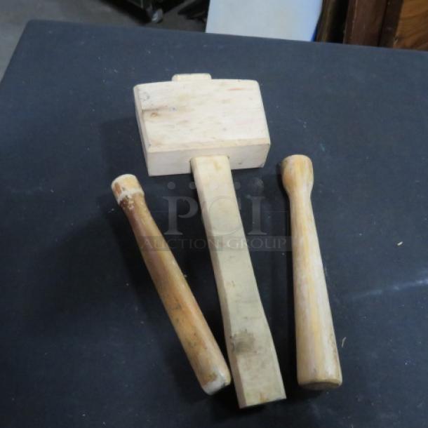 Assorted wooden utensil set, including two mallets and a pestle, showing signs of use, minor scuffs.