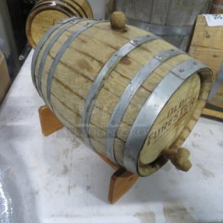 Old Forester wooden whiskey barrel on a stand, metal hoops, visible branding, used condition, suitable for display.