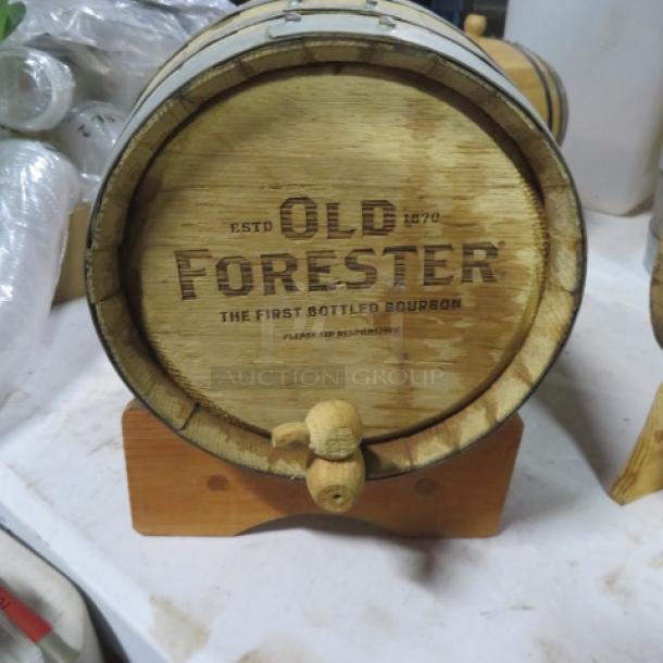 Old Forester wooden whiskey barrel on a wooden stand, featuring brand logo and "The First Bottled Bourbon" text.
