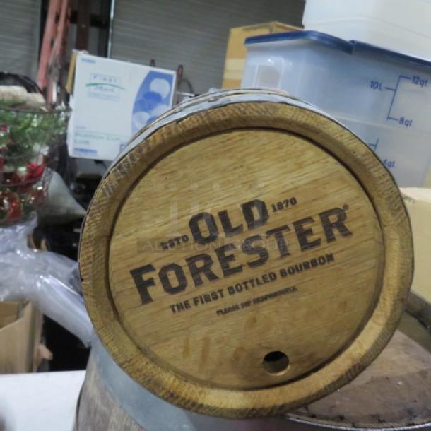 Wooden whiskey barrel with "Old Forester" logo, featuring wooden staves and metal hoops. Used condition.