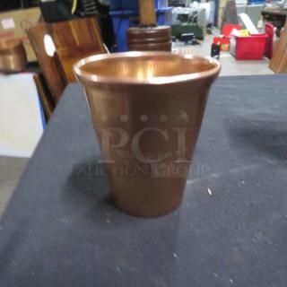 Copper mule cup branded Woodford Reserve, cylindrical shape, polished finish, good condition, engraved logo visible.