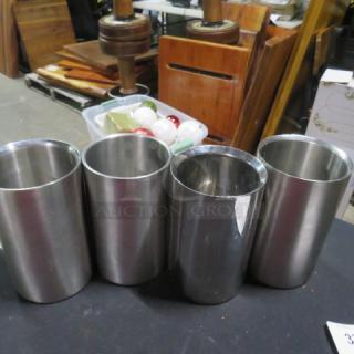 Four stainless steel wine/champagne holders in good condition, cylindrical design, ideal for entertaining.