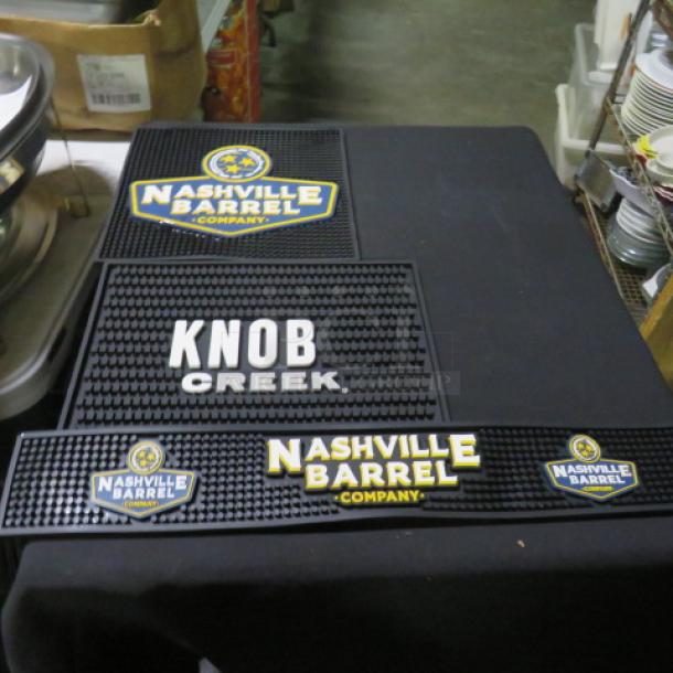 Assorted bar mats featuring Nashville Barrel Company and Knob Creek designs. Black rubber with logos in good condition.