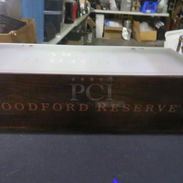 Woodford Reserve wooden domed bar center, featuring engraved branding. Appears in good condition with a dark wood finish.
