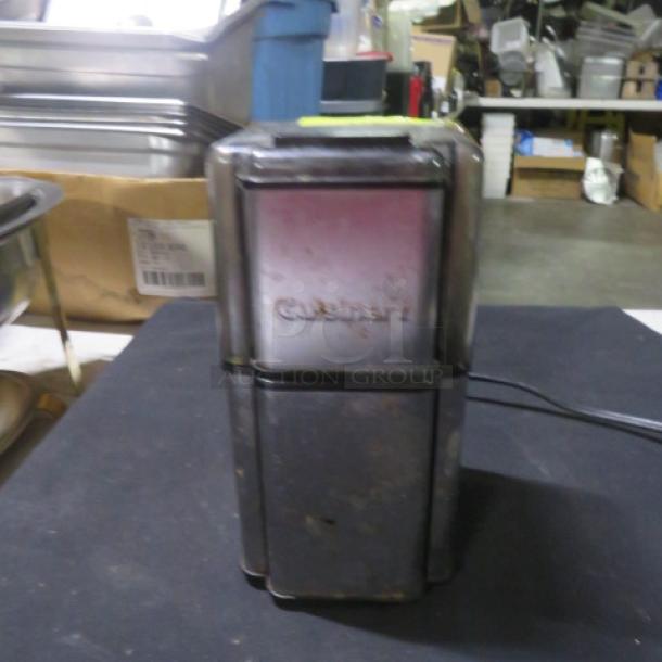 Cuisinart DCG-12BC coffee grinder in fair condition. Visible branding on front. Electric cord attached.