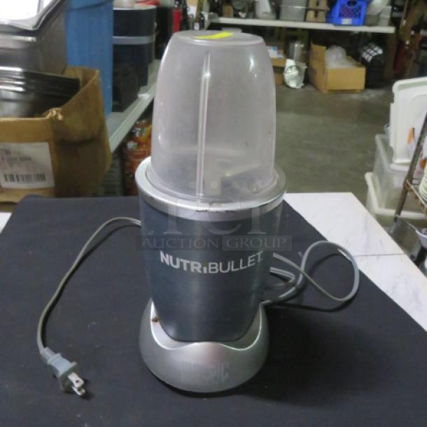 Nutri Bullet blender model NB101B in good condition, features include a power cord and blending cup with lid.