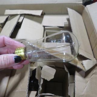 Box of vintage-style light bulbs with brass bases, partially unpacked. Mint condition, ideal for collectors or decorators.