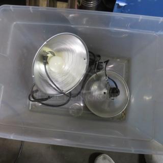 Two metal heat lamps in a plastic bin; one with a bulb, cords visible. Good condition. Model: 2XBID.