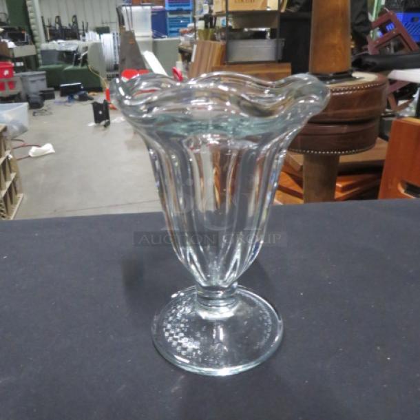 Clear glass sundae dish with a scalloped edge. Excellent condition, no visible markings or labels. Model: 11XBID.