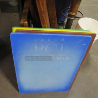 Assorted color cutting boards, 18x24 inches, visible wear, includes blue, green, yellow, and brown boards.