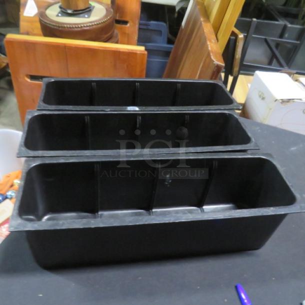 Black plastic bottle holder, 3 compartments, in good condition. Ideal for organizing bottles, durable material. No visible labels.