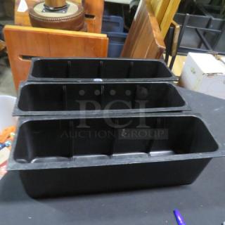 Black plastic bottle holder, 3 compartments, in good condition. Ideal for organizing bottles, durable material. No visible labels.