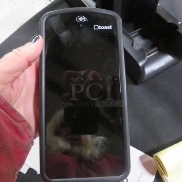 Toast GO 1 POS handheld terminal TG100 with charging station, touchscreen, logo visible, in good condition.