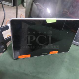 Toast POS monitor with wall mount bracket, black screen, visible labels indicating codes. Appears in good condition.