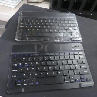 Wireless Keyboard 2XBID, black, compact design, two units. One sealed, new condition, featuring blue function keys.