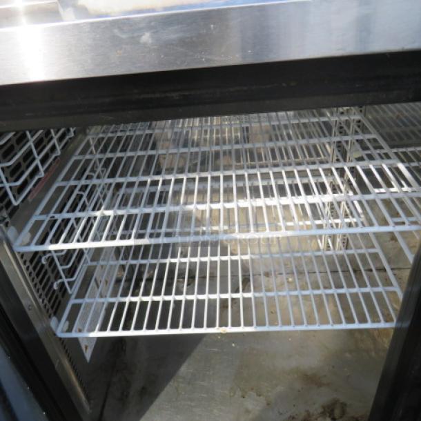 Turbo Air glass door back bar cooler, model TBB-24-60SGN, with three racks and casters. Measures 61x24x38.5 inches. 120 Volt.