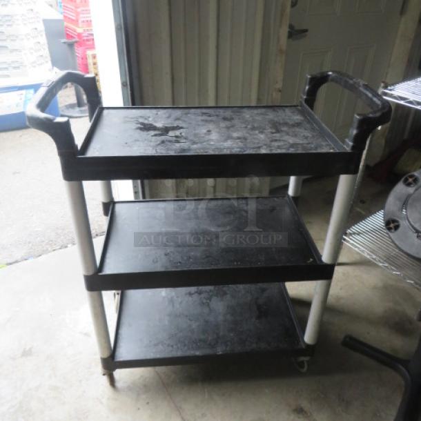 Three-shelf poly cart on casters, measuring 32.5x16x38 inches. Features sturdy handles, black color, used condition.