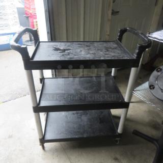 Three-shelf poly cart on casters, measuring 32.5x16x38 inches. Features sturdy handles, black color, used condition.