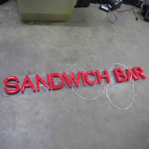 Red lighted sign spelling "Sandwich Bar," measures 61x7 inches. Features bold lettering, suitable for commercial display.