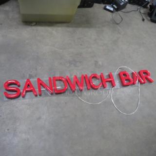 Red lighted sign spelling "Sandwich Bar," measures 61x7 inches. Features bold lettering, suitable for commercial display.