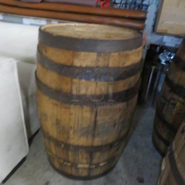Wooden whiskey barrel with metal hoops, rustic appearance. Good condition, suitable for storage or decorative use.