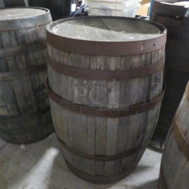 Vintage wooden whiskey barrel with metal bands, weathered finish. Ideal for decor or repurposing. Good condition.