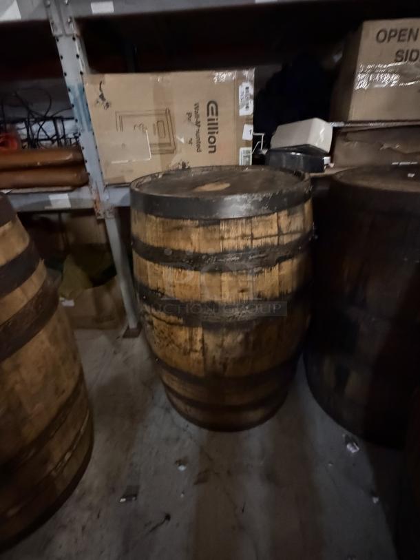 Wooden whiskey barrel stamped "Jack Daniels" on top, visible wear, medium-sized, used for aging or display.