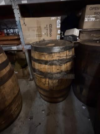 Wooden whiskey barrel stamped "Jack Daniels" on top, visible wear, medium-sized, used for aging or display.