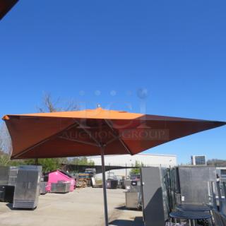 Orange XL Sunbrella outdoor umbrella, sturdy metal frame, excellent condition, ideal for patio or garden use.