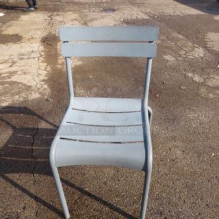 Aluminum patio chair, model 4XBID, with slatted back and seat design, in used condition on outdoor pavement.