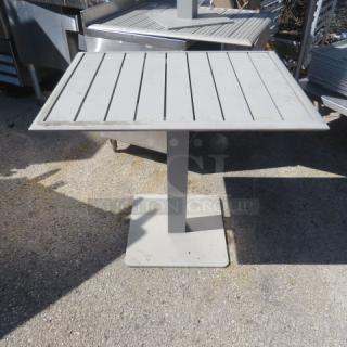 Gray patio table, 24x30x30 inches, slatted top, pedestal base, mild wear, suitable for outdoor use.