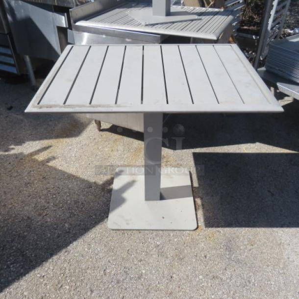 Square patio table, 24x30x30 inches, with a slatted metal top and pedestal base. Light wear, suitable for outdoor use.