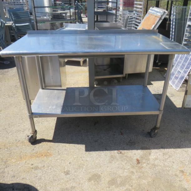 Stainless steel table with under shelf on casters, 60x30x40.5 inches, durable and mobile for versatile use.
