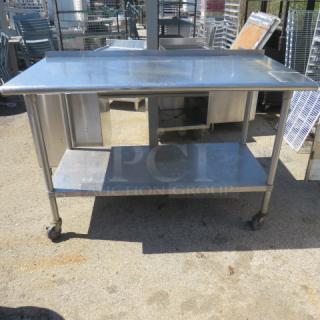 Stainless steel table with under shelf on casters, 60x30x40.5 inches, durable and mobile for versatile use.