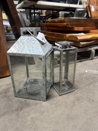 Assorted lanterns in metal and glass, good condition, with sale tag marked "2XBID"; suitable for indoor or outdoor use.