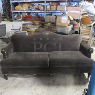 Brown velvet cushioned couch, 80x35x35, with studded trim and curved back. Good condition; stylish and elegant design.