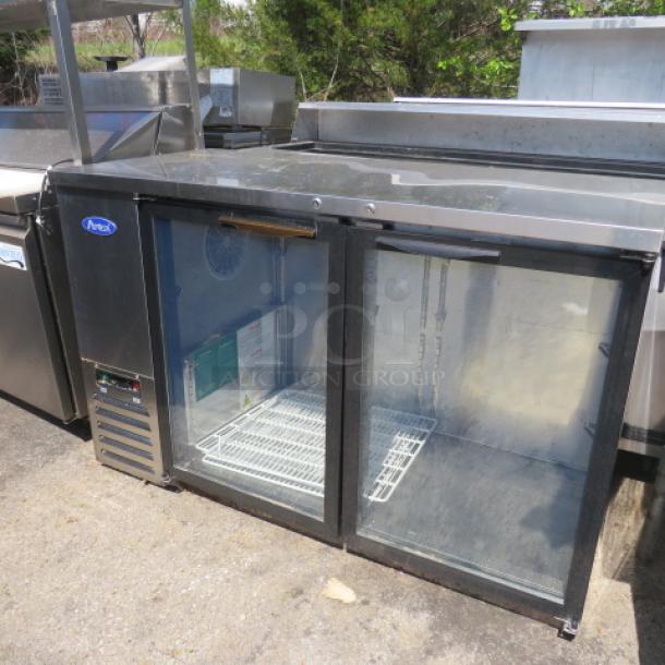 Atosa 2-door glass back bar cooler, model MBB59GGR, with 4 racks on casters, 115V. Dimensions: 58x27x37 inches.