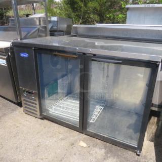 Atosa 2-door glass back bar cooler, model MBB59GGR, with 4 racks on casters, 115V. Dimensions: 58x27x37 inches.