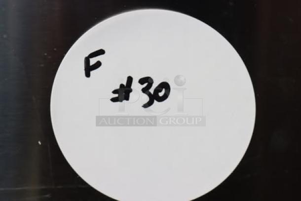 White round sticker with handwritten text "F #30" on a metal surface.