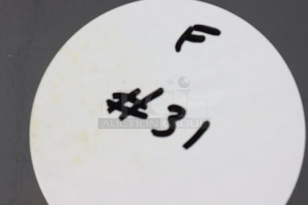 White circle tag marked with "F #31" in black handwriting, attached to the item for identification.
