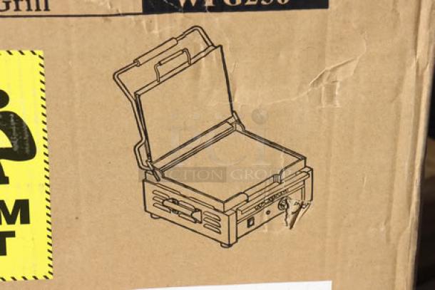 Brand new Waring WFG250 Panini Grill in box, showing illustration and model details, 14.5"x11" cooking surface, 120V, 1800W.