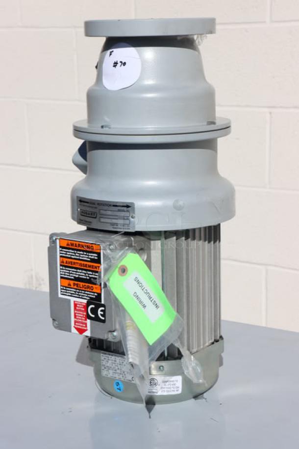 Brand new Hobart FD4/125-1 commercial garbage disposer, 1 1/4 hp, with short upper housing. Tags show safety warnings.