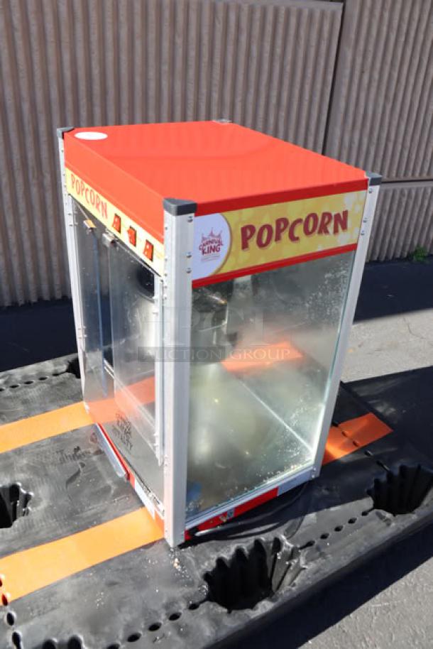Carnival King PM50NR 12 oz. red commercial popcorn machine in good condition, transparent sides, 120V power.