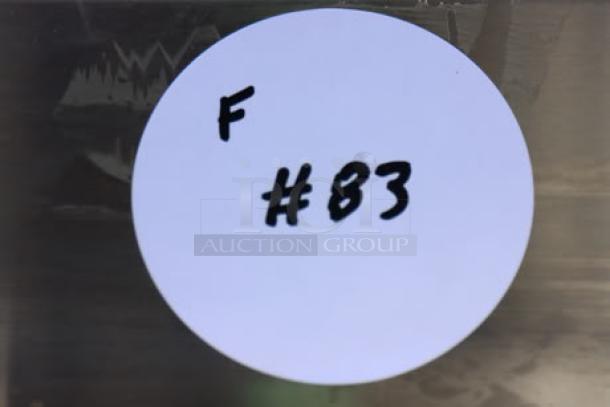 White round label with hand-written text "F #83" on a metallic surface.