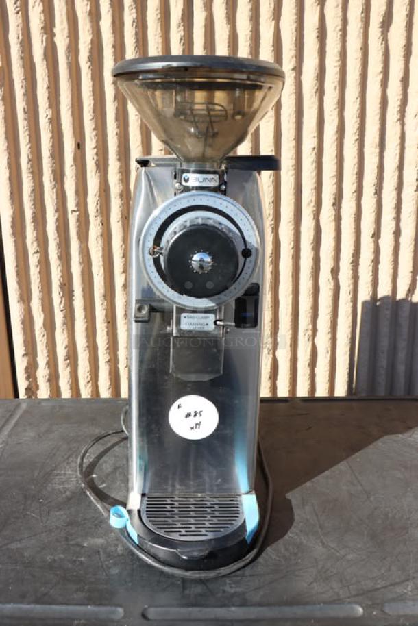 Bunn 55600.0100 GVH-1 Coffee Grinder, stainless steel, slightly used, serial number GVH0006397, on table surface.