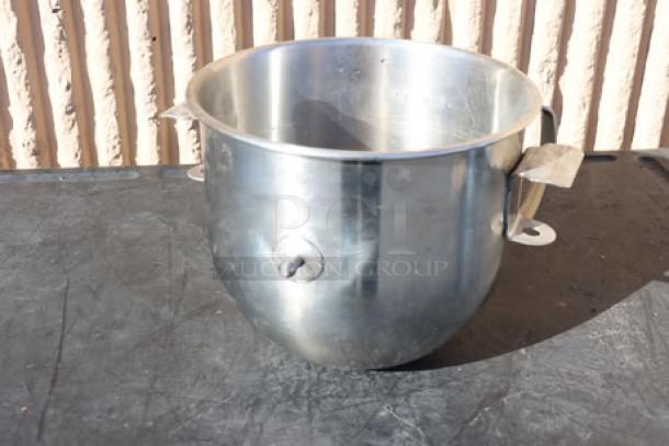 8 Qt. metal mixer bowl on dark surface, stainless steel, handles on both sides, reflective finish, part of auction lot.