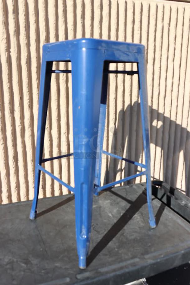 Blue metal barstool with back, visible wear on legs, sturdy construction, suitable for commercial or home use.