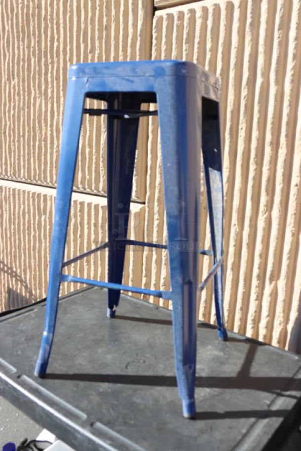 Blue metal barstool with back, shown outdoors, highlighting sturdy design. Part of massive mixed lot auction.