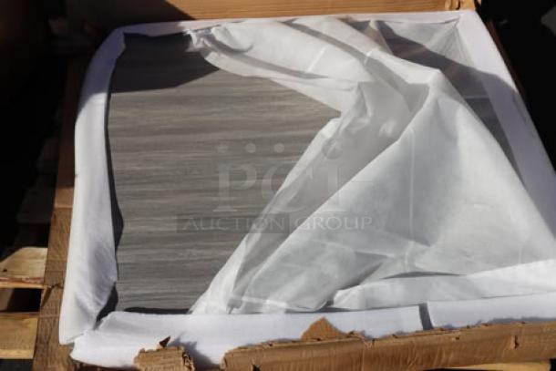 Packaged table top from a 2-pallet mixed lot; visible gray wood pattern; item in damaged packaging.