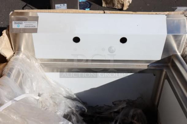Stainless steel commercial sink with dual mounting holes, partially unpacked, in damaged packaging.
